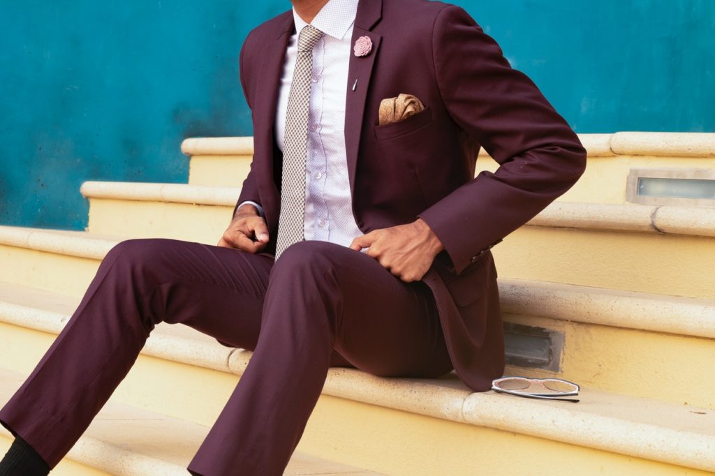 Burgundy suit with mustard yellow accents-sitting-on-stairs-beside-sunglasses