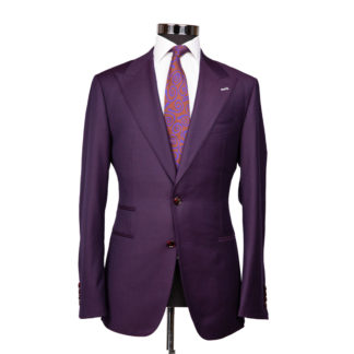 A plum colored suit jacket on a body form with a white shirt and mauve and blue patterned tie on a white background
