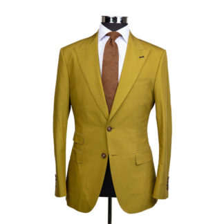 A mustard yellow suit jacket on a body form with a white shirt and a light brown speckled tie on a white background