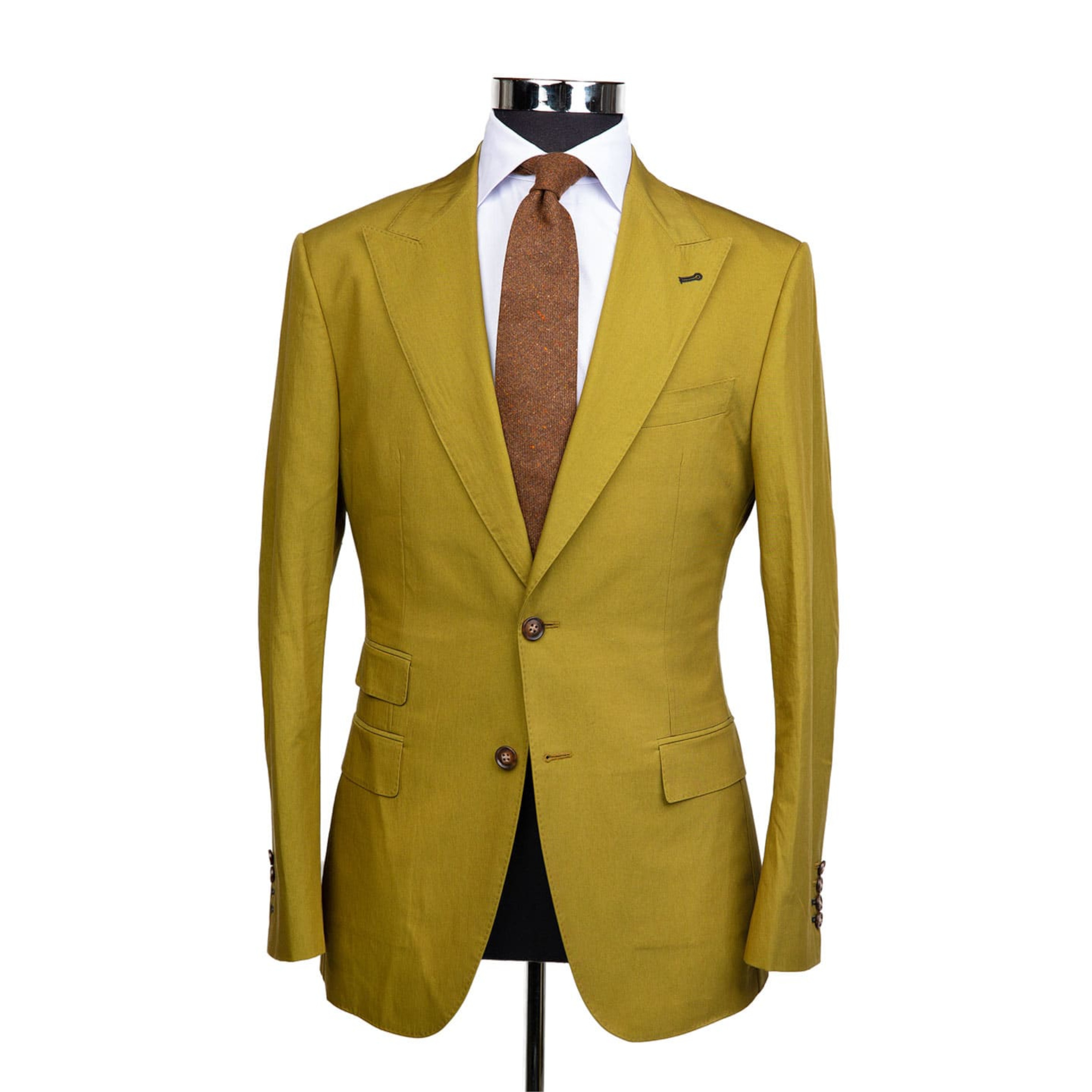A mustard yellow suit jacket on a body form with a white shirt and a light brown speckled tie on a white background