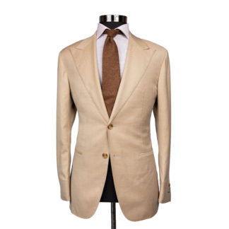 A light tan suit coat on a body form with a white shirt and brown speckled tie on a white background