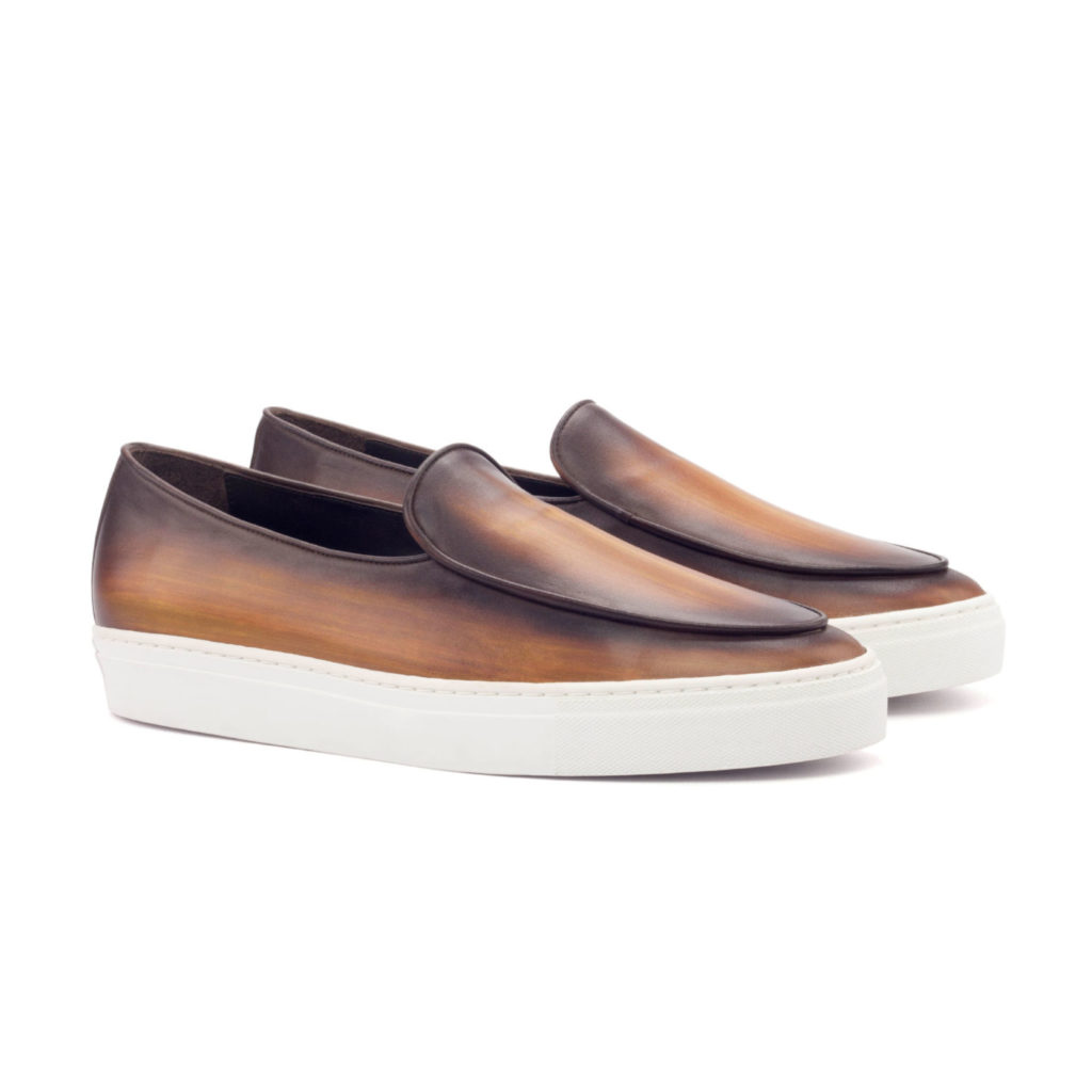 The Sport Loafer: Brushed Cognac. Cognac patina slip on style sneakers with white soles on a white background