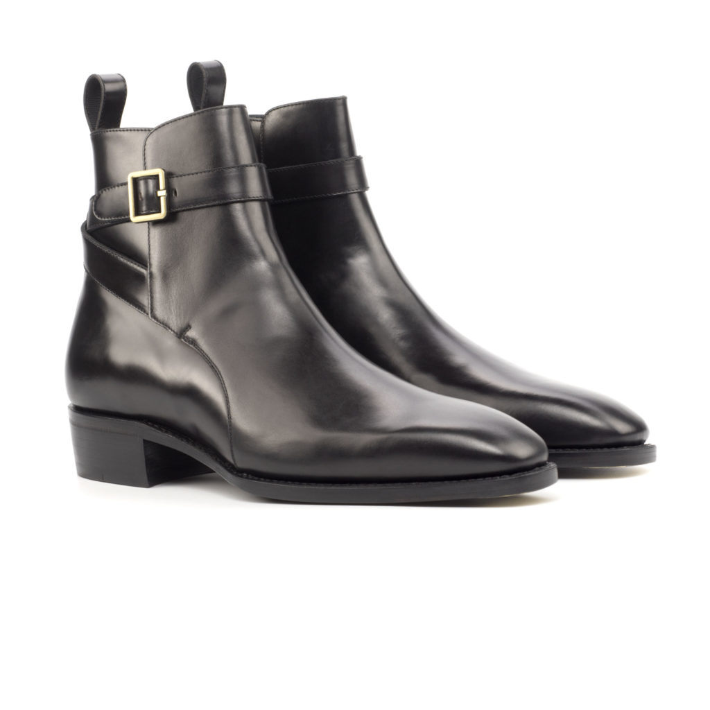 The Stallion: Black. Black polished calf leather riding style ankle boot with strap and buckle on a white background