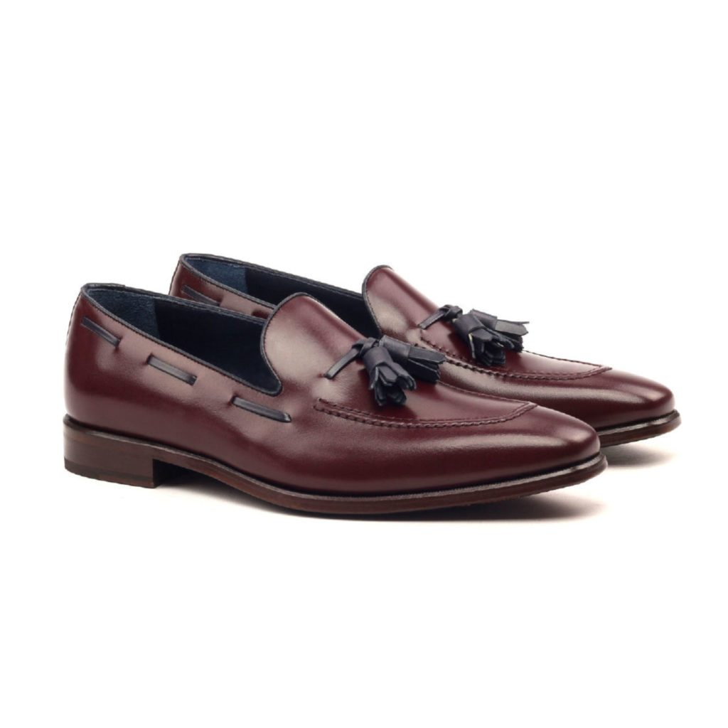 The Richmond: Tasseled Caramel. Burgundy box calf leather loafers with navy tassels against white background.