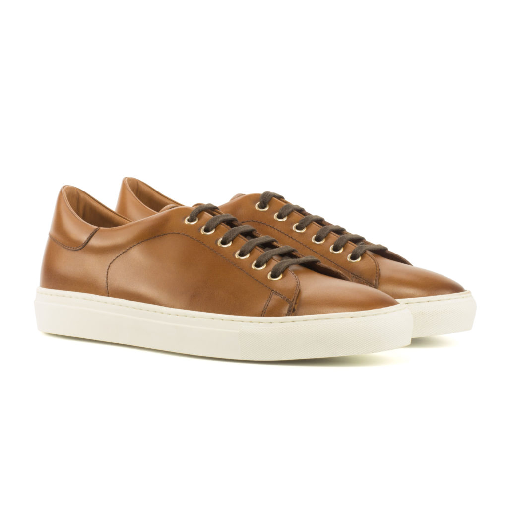 The Plimsoll: Cognac. Box calf lace up trainer style shoes with white soles on a white background