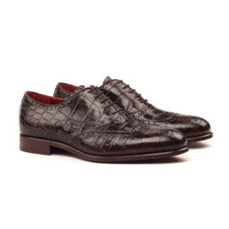 The Agent: Chocolate Croc. Front facing view of dark brown painted croco leather men's style lace up dress shoes with decorative toe cap on a white background