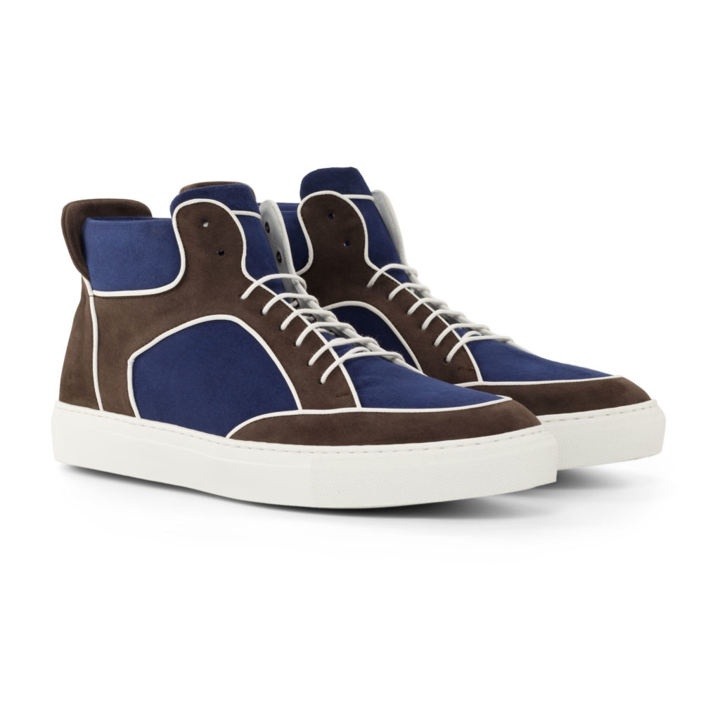The High Top: Backcourt Vintage. Front side view of navy kid suede, brown kid suede high top style sneakers with white soles on a white background