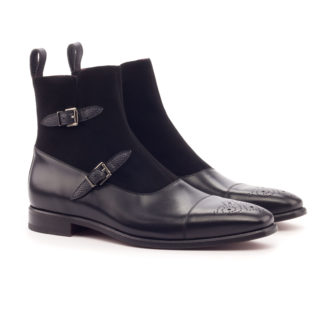 The Octavian: Onyx. Front side view of black kid suede, black painted calf, black pebble grain leather ankle boots with 2 buckles and a decorative toe cap on a white background